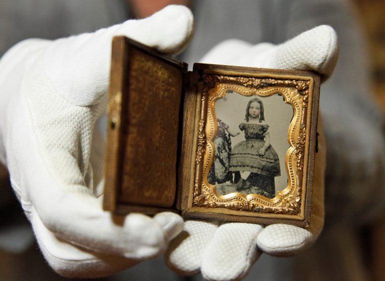  Ann Drury Wellford, manager of Photographic Services for The Museum of the Confederacy, holds a Civil War battlefield photo at the museum in Richmond, Va., Friday, May 25, 2012. Private Thomas W. Timberlake of Co. G, 2nd Virginia Infantry found this childâs portrait on the battlefield of Port Republic, Virginia, between the bodies of a Confederate soldier and a Federal soldier. The Museum of the Confederacy is publicly releasing eight images recovered on battlefields of unidentified persons in the admittedly remote chance a descendant might recognize a facial resemblance or make a connection the battlefields where they were found. (AP Photo/Steve Helber)  