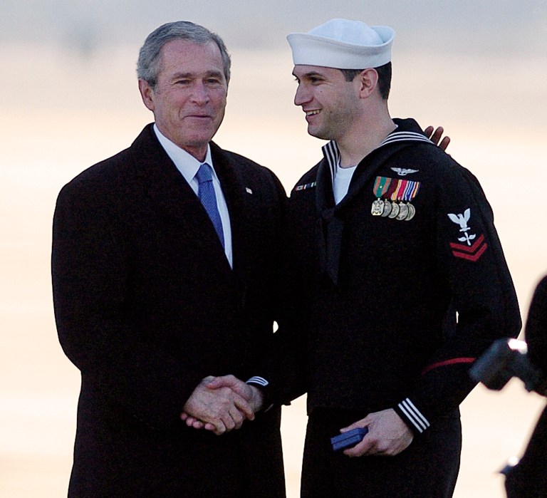 President George W. Bush, shakes hands with Navy Petty Officer, Jesse Alvarado, right, after presenting him with the President's Volunteer Service Award Saturday, Jan. 10, 2009, at Naval Station Norfolk in Norfolk, Va. Bush, was in Norfolk to take part in the commissioning ceremony for the aircraft carrier, USS George H. W. Bush at Naval Station Norfolk.Â (AP Photo)