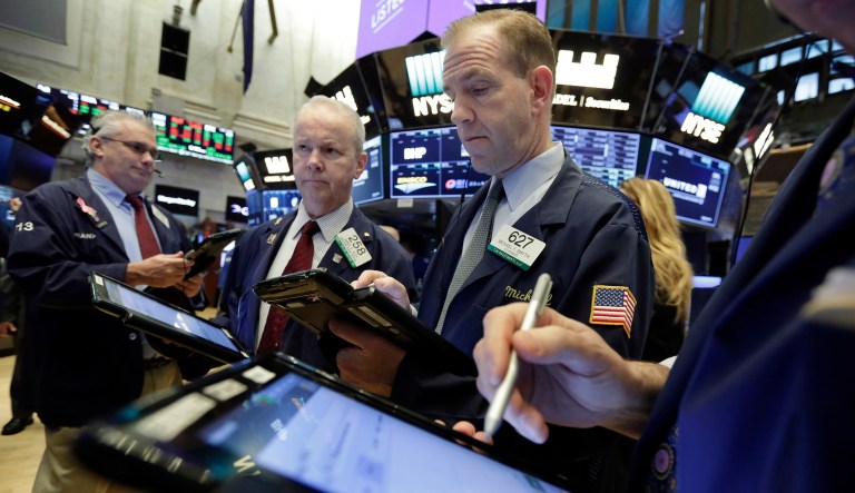 In this photo from Friday, traders Frank O'Connell, James Riley, and Michael Smyth, left to right, work on the floor of the New York Stock Exchange. The three major stock market indexes tumbled Thursday, with the blue-chip Dow Jones Industrial Average sliding as much as 586 points, after Trump outlined a plan for the U.S. to charge levies of 25 percent on overseas steel and 10 percent on overseas aluminum. (AP Photo/Richard Drew)