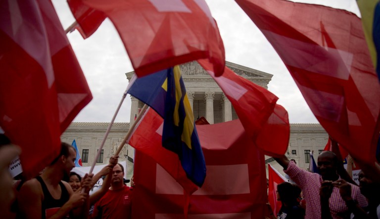 Demonstrators in support of same-sex marriage wave Human Rights Campaign "Equality" flags before the same-sex marriage ruling outside the Supreme Court in Washington on June 26, 2015.
