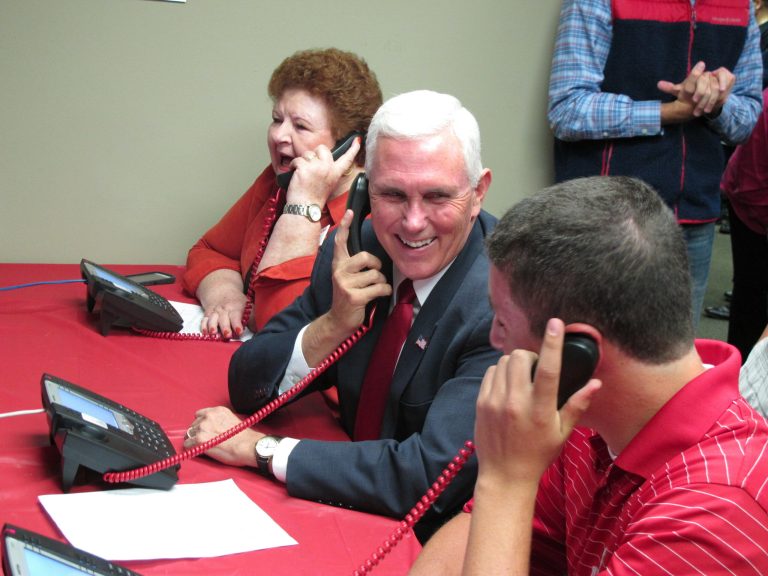 Republican vice presidential candidate Indiana Gov. Mike Pence makes phone calls along with campaign volunteers at a Republican party office on Tuesday, Sept. 27, 2016, in Fitchburg, Wis. (AP Photo/Scott Bauer)