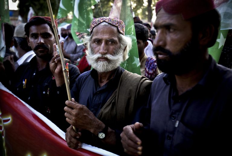 In this Monday, May 6, 2013 photo, People from the Baluch Bugti tribe who were evicted from their villages after their leader was killed by the regime of Pakistan's military ruler Pervez Musharraf, rally demanding repatriation to their native towns to take part in May 11 polls in Islamabad, Pakistan. The graffiti on walls around this Pakistani provincial capital hold a dire warning ahead of this weekend's national elections, 