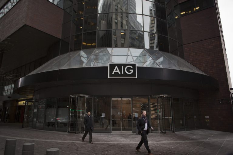 Pedestrians walk past AIG headquarters in New York. The insurer posted lower quarterly earnings than Wall Street expected after losses from the California wildfires and a charge of more than $6 billion from President Trump's tax overhaul. Photographer: Victor J. Blue/Bloomberg
