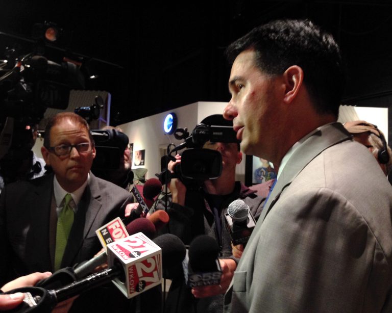 Wisconsin Gov. Scott Walker speaks to reporters before the Wisconsin Economic Development Corp. meeting Monday, July 28, 2014, in Wauwatosa, Wis. Walker says he would support a proposal aimed at keeping companies that receive state aid from outsourcing jobs. (AP Photo/M.L. Johnson)