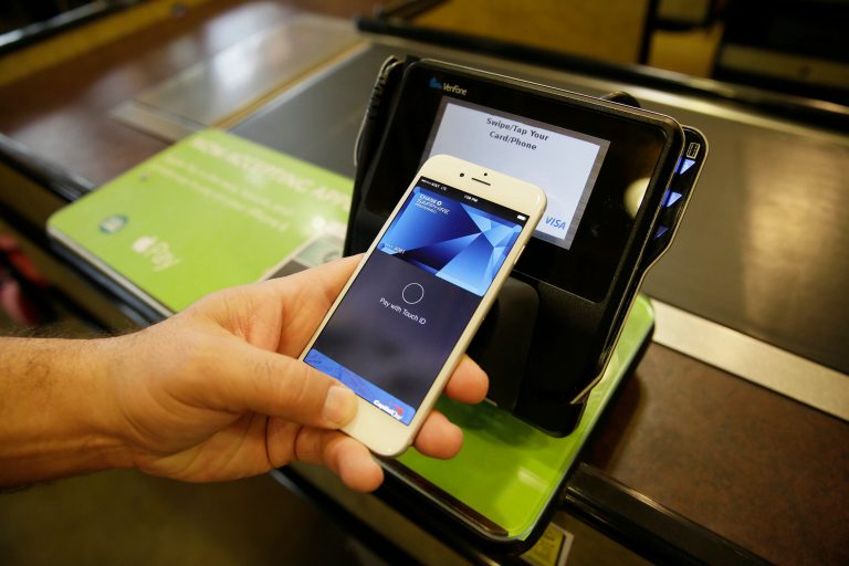 In this photo taken Friday, Oct. 17, 2014, Eddy Cue, Apple Senior Vice President of Internet Software and Services, demonstrates the new Apple Pay mobile payment system at a Whole Foods store in Cupertino, Calif. The new system launches on Monday. (AP Photo/Eric Risberg)
