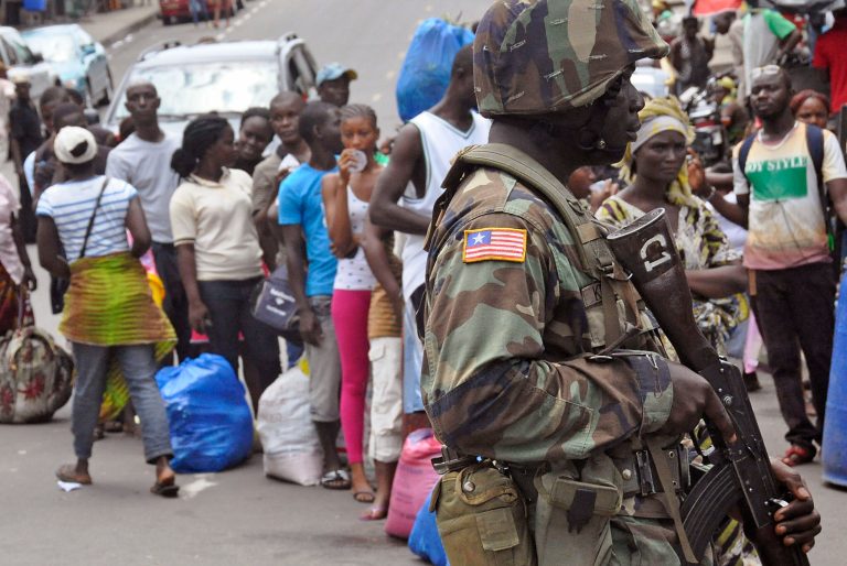 A Liberian soldier, right,  scans people for signs of the Ebola virus, as they control people from entering the West Point area in the city of Monrovia, Liberia, Saturday, Aug. 23, 2014. The outbreak also continues to spread elsewhere in West Africa, with 142 more cases recorded, bringing the new total to more than 2,600 with over 1,400 deaths, the World Health Organization said Friday. Most of the new cases are in Liberia, where the government was delivering donated rice to a slum where 50,000 people have been sealed off from the rest of the capital in an attempt to contain the outbreak. (AP Photo/Abbas Dulleh)