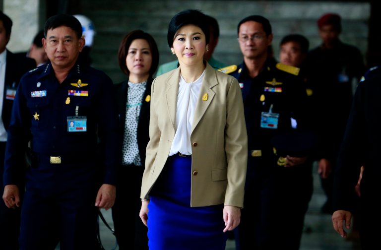 Prime Minister Yingluck Shinawatra, center, leaves the Thai Air Force headquarters after a cabinet meeting in Bangkok, Thailand, Tuesday, Feb. 25, 2014. Anti-government protesters are pressing for the resignation of Yingluck and want her to be replaced by an appointed interim government to implement reforms they say are needed to fight corruption and permanently remove Yingluck's wealthy family from politics. (AP Photo/Wason Wanichakorn)