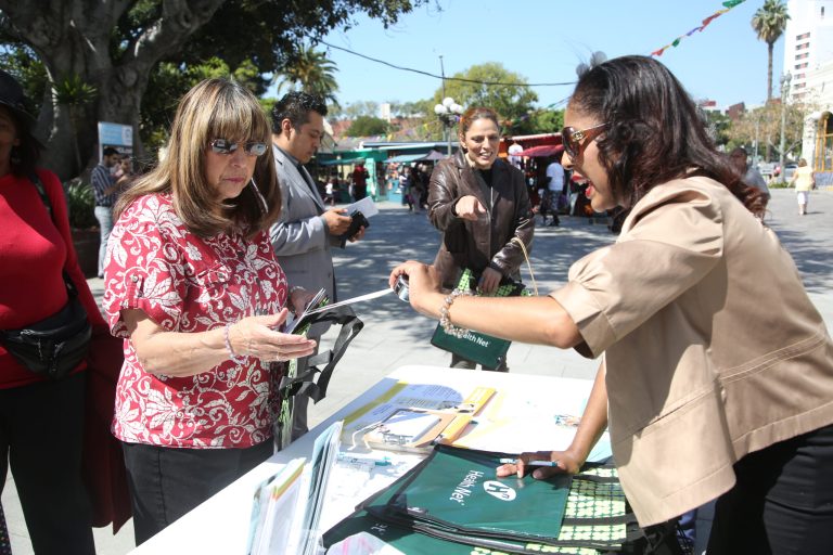 A woman gets insurance information during a healthcareÂ rally.Â Minnesota's regulators announced that the average rate increase for Obamacare enrollees would range from 14 to 49 percent in 2016.Â (AP Photo/Nick Ut)
