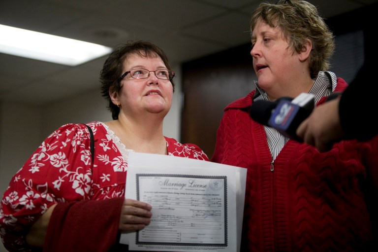 In this photo taken on Thursday, Dec. 26, 2013, Shelly Eyre, left, holds the marriage license just issued to her and her partner Cheryl Haws at the Utah County Clerk's office in Provo, Utah. The Supreme Court has put same-sex marriages on hold in Utah, at least while a federal appeals court more fully considers the issue. (AP Photo/The Daily Herald, Mark Johnston)