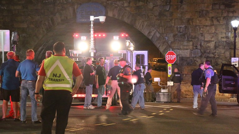 Bomb squad personnel stand around the scene of an explosion near the train station early Monday in Elizabeth, N.J. (Jessica Remo/NJ Advance Media via AP)