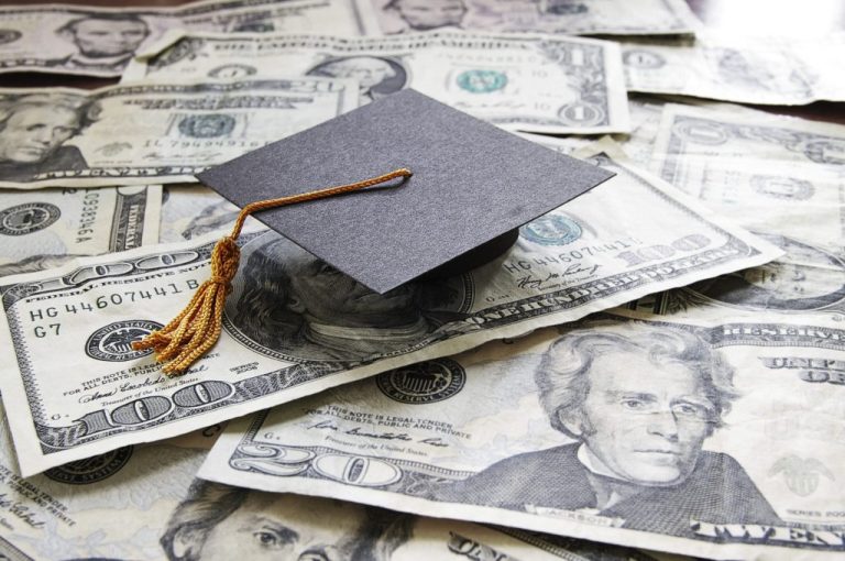 A graduation cap on top of $20 bills.