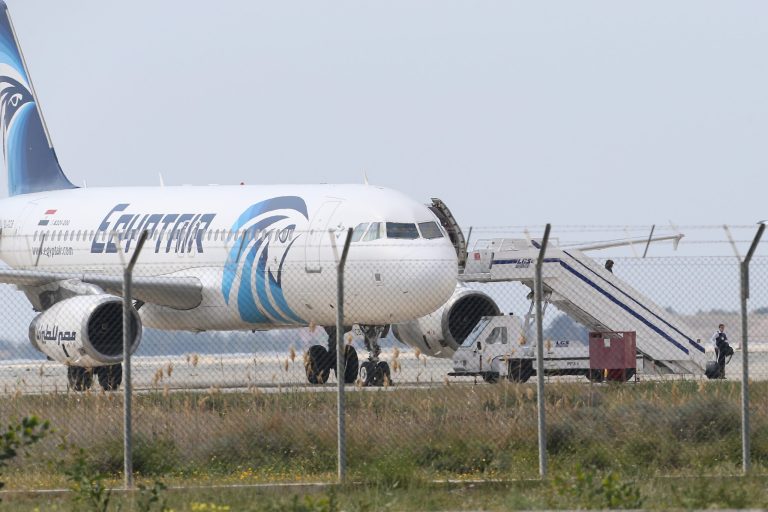 Passengers leave the hijacked aircraft of Egyptair is seen on the ground after landing at Larnaca airport on Tuesday. The plane was hijacked while flying from the Egyptian Mediterranean coastal city of Alexandria to the capital, Cairo, and later landed in Cyprus where some of the women and children were allowed to get off the aircraft, according to Egyptian and Cypriot officials. (AP Photo/Petros Karadjias)