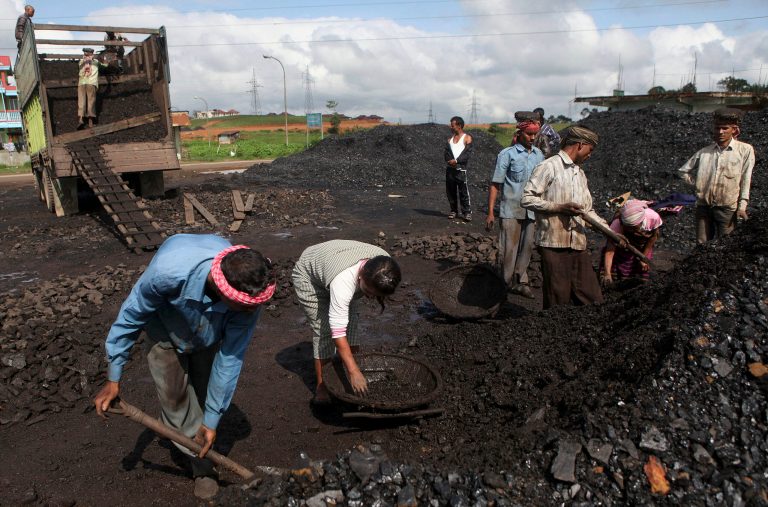 In this July 1, 2013 photo, Indian laborers dig a roadside coal depot at Khliehriet in Meghalaya, India. For six years in a row, India's monopoly coal producer has missed its production targets, leading to chronic electricity shortages and sending power producers scrambling for pricier imports. But what looks like a looming crisis could turn out to be an almost accidental energy overhaul. India has relied for decades on cheap coal to provide electricity for burgeoning industry and fast-expanding cities, putting aside worries about pollution and global warming. (AP Photo/Anupam Nath)