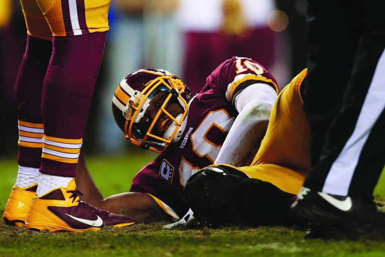 Win McNamee/Getty Images
Redskins rookie quarterback Robert Griffin III will be out a minimum of six months after having his knee reconstructed on Wednesday.