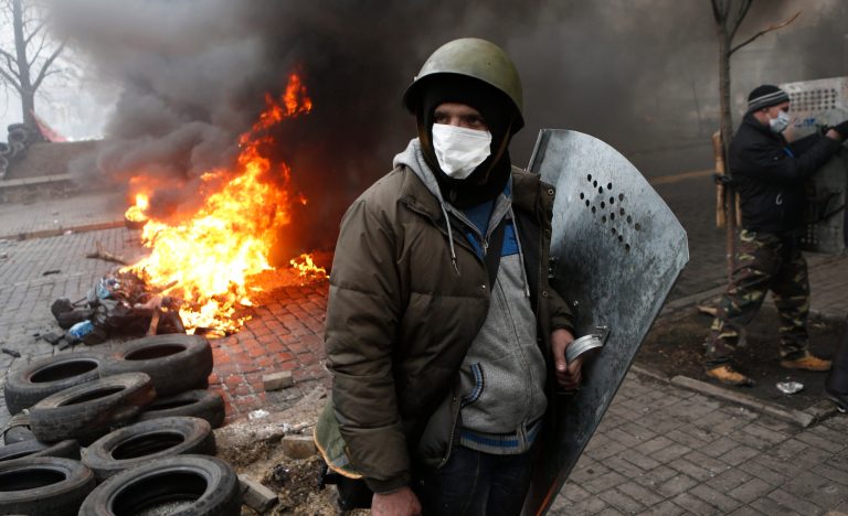 Anti-government protesters man a barricade in central Kiev, Ukraine, Thursday, Feb. 20, 2014. A brief truce in Ukraine's embattled capital failed Thursday, spiraling into fierce clashes between police and anti-government protesters. (AP Photo/Darko Bandic)