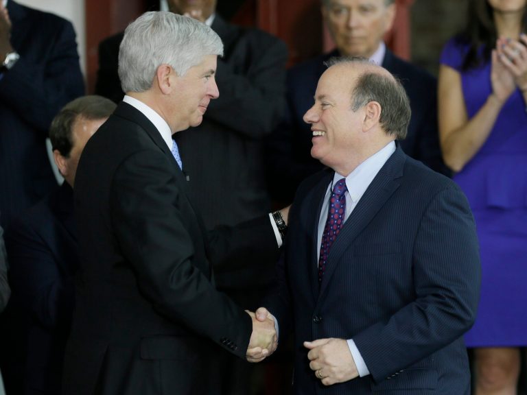 Michigan Gov. Rick Snyder introduces Detroit Mayor Mike Duggan before signing legislation to provide state funding for Detroit municipal pensions as part of city's bankruptcy process during a ceremony at the refurbished Globe Building in Detroit, Friday, June 20, 2014. (AP Photo/Carlos Osorio)