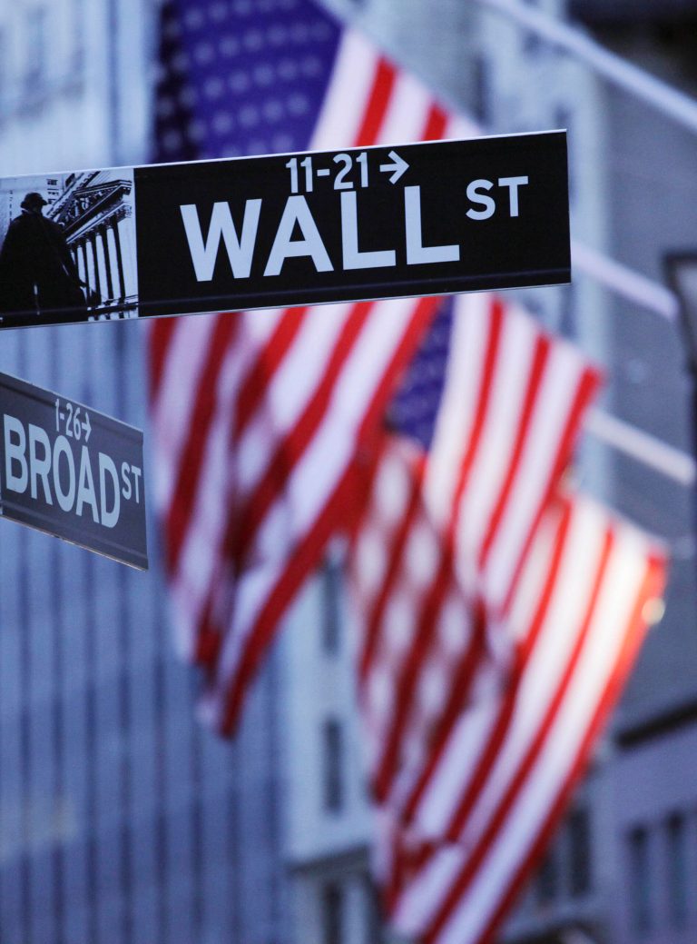 FILE - In this Aug. 9, 2011 file photo, American flags hang behind a Wall Street sign outside the New York Stock Exchange, in New York. World stock markets were mostly weaker Friday, May 30, 2014, after a government report showed the U.S. economy shrank in the first quarter and the U.S. dollar lost value against major Asian currencies. (AP Photo/Mark Lennihan, File)