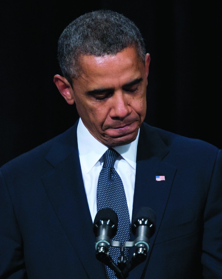 FILE - This Dec. 16, 2012 file photo shows President Barack Obama pausing as he speaks during an interfaith vigil for the victims of the Sandy Hook Elementary School shooting, at Newtown High School in Newtown, Conn. Four years after he was the fifth-youngest president to take the oath of office, Barack Obama now is 51, his hair more gray, his face more lined. The changes aren't all physical: As he enters Term Two, he is sounding more confident, vowing a harder line on negotiations, relying more on trusted allies, promising less, expressing more cynicism about the grip of partisanship on Washington. And perhaps most important, he seems more convinced of a need to keep the public with him, coming full circle to his people-driven 2008 campaign. (AP Photo/Evan Vucci, File)