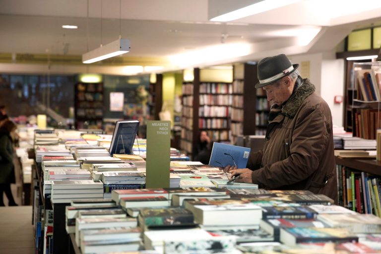 A customer of a bookstore checks some books in Athens Tuesday, Feb. 4, 2014. Leading Greek writers and publishers gathered at a bookstore in central Athens Tuesday to express their opposition to the proposed lifting of price controls on books sold in the recession-hit country. (AP Photo/Petros Giannakouris)