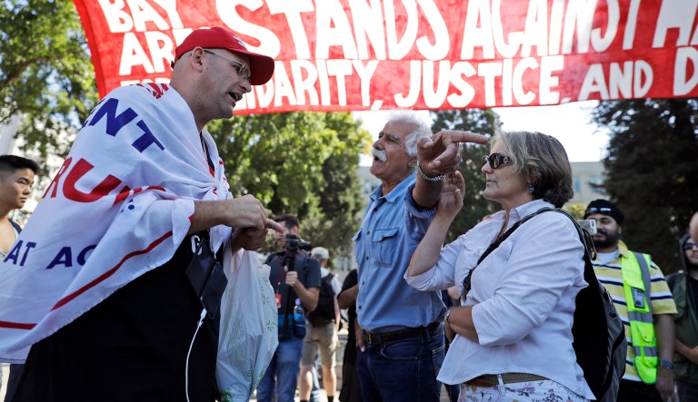 Donald Trump supporter Arthur Schaper, left, argues his position with Mustafa Payrvand, center, and Christina Tunnah during a free speech rally Sunday, Aug. 27, 2017, in Berkeley, Calif. (AP Photo/Marcio Jose Sanchez)