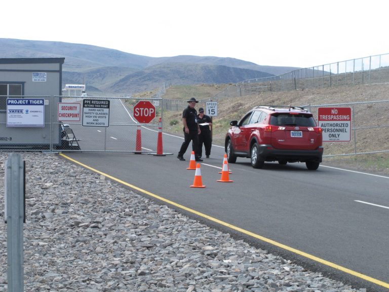 Security guards stop a car Friday Aug. 1, 2014, at the gate to the site Tahoe Reno Industrial Center about 15 miles east of Reno, Nevada where Tesla Motors has broken ground as one of the possible places to build a $5 billion 
