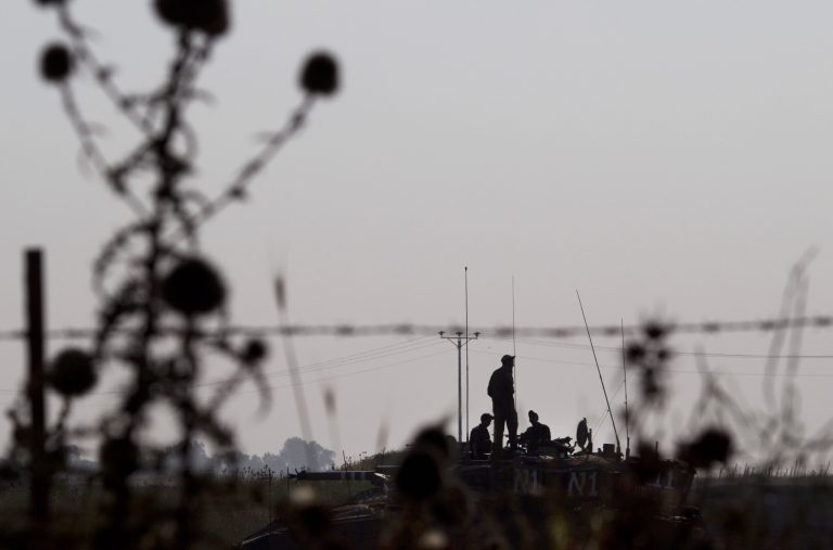 Israeli soldiers stand atop of a tank during a military exercise in the Israeli controlled Golan Heights, near the border with Syria, Tuesday, May 7, 2013. (AP Photo/Ariel Schalit)