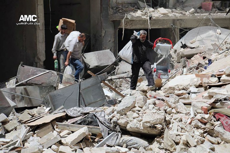This photo provided by the anti-government activist group Aleppo Media Center (AMC), which has been authenticated based on its contents and other AP reporting, shows Syrian people carry their belongings from a building that was hit by Syrian government airstrike in Aleppo , in Aleppo, Syria, Monday, April 28, 2014. Dozens of people were killed and wounded in fighting between pro-Assad forces and rebels in the northern city of Aleppo on Sunday, reported the Britain-based Syrian Observatory for Human Rights. The fight for Aleppo is particularly important now, with analysts saying they expect Assad's forces will try wrest as much of the city as possible before elections. (AP Photo/Aleppo Media Center AMC)