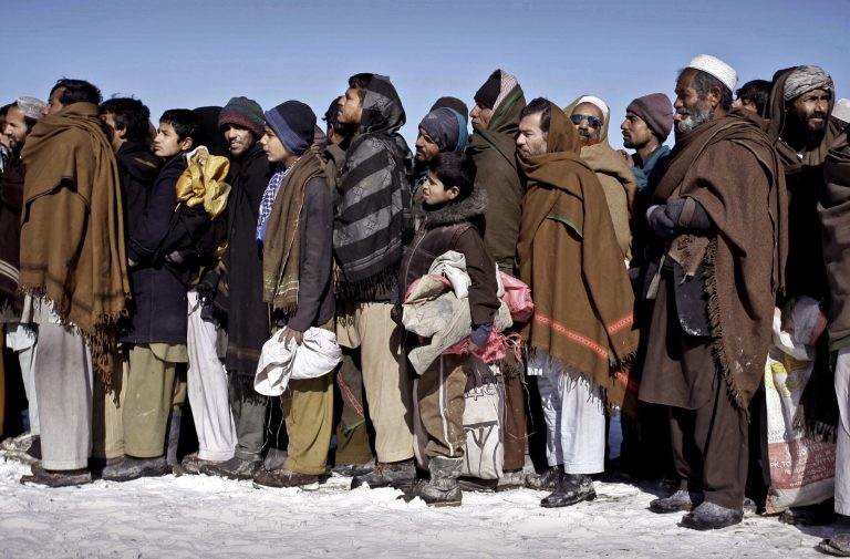   Internally displaced Afghans wait in line to receive firewood donated by Welt Hunger Hilfe 'German Agro Action' in Kabul, Afghanistan, Sunday, Dec. 30, 2012. Around 240 internally displaced families received firewood. (AP Photo/Musadeq Sadeq)  