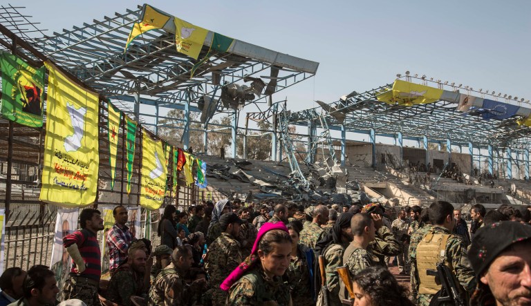 Members of the U.S.-backed Syrian Democratic Forces (SDF) celebrate at stadium that was the site of Islamic State fighters' last stand in the city of Raqqa, Syria, Friday, Oct. 20, 2017. Syrian Kurdish-led forces backed by the U.S. declare victory in the devastated northern city of Raqqa days after it cleared it from members of the Islamic State group. (AP Photo/Asmaa Waguih)
