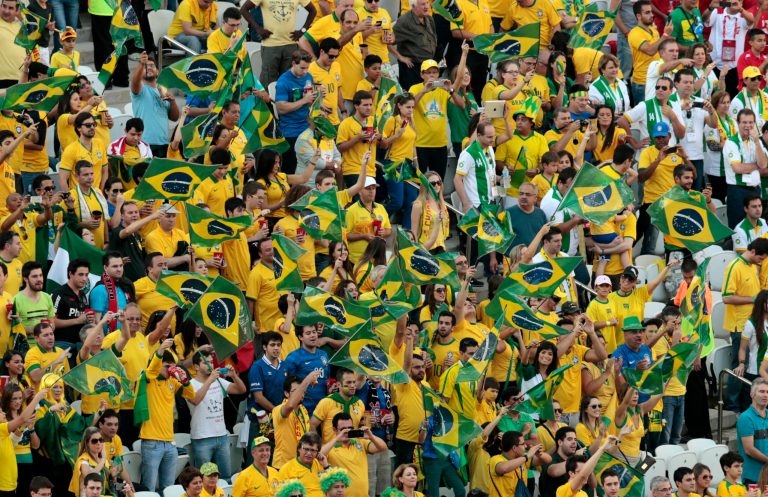 Fans cheer before the group A World Cup soccer match between Brazil and Croatia, the opening game of the tournament, in the Itaquerao Stadium in Sao Paulo, Brazil, Thursday, June 12, 2014. (AP Photo/Shuji Kajiyama)