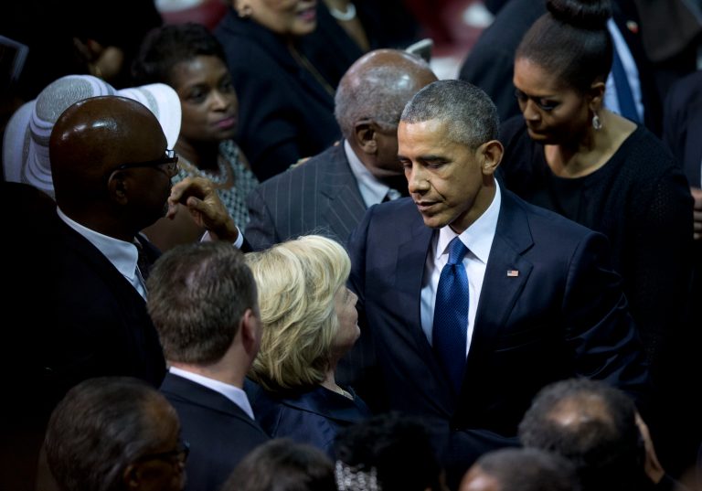 President Barack Obama looks to Democratic presidential candidate, former Secretary of State Hillary Rodham Clinton as he and first lady Michelle Obama leave services honoring the life of Rev. Clementa Pinckney, Friday, June 26, 2015, at the College of Charleston TD Arena, in Charleston, S.C. (AP Photo/Carolyn Kaster)