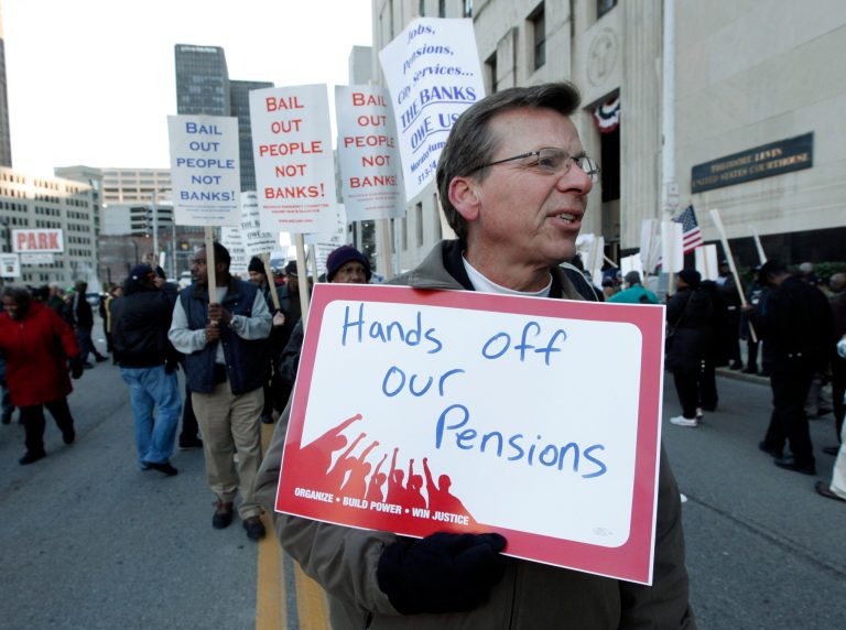 Dennis Marton walks with protesters at a rally outside a federal courthouse in Detroit on Oct. 23. Detroit's emergency manager and his legal team squared off against unions and pension funds that claim the city isn't qualified to scrub its books clean under Chapter 9 bankruptcy. (AP Photo/Paul Sancya)