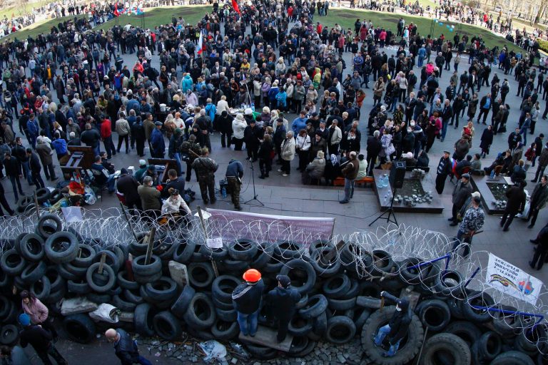 People gathered in front of a barricade at the regional administration building in Donetsk, Ukraine, Monday, April 7, 2014.   A Ukrainian news agency is reporting that pro-Russian separatists who have seized the regional administration building in the eastern Ukrainian city of Donetsk proclaimed the region an independent republic. The activists on Monday also called for a referendum on the sovereignty of the Donetsk region, which borders Russia, to be held no later than May 11, the Interfax news agency reported. (AP Photo/Andrey Basevych)
