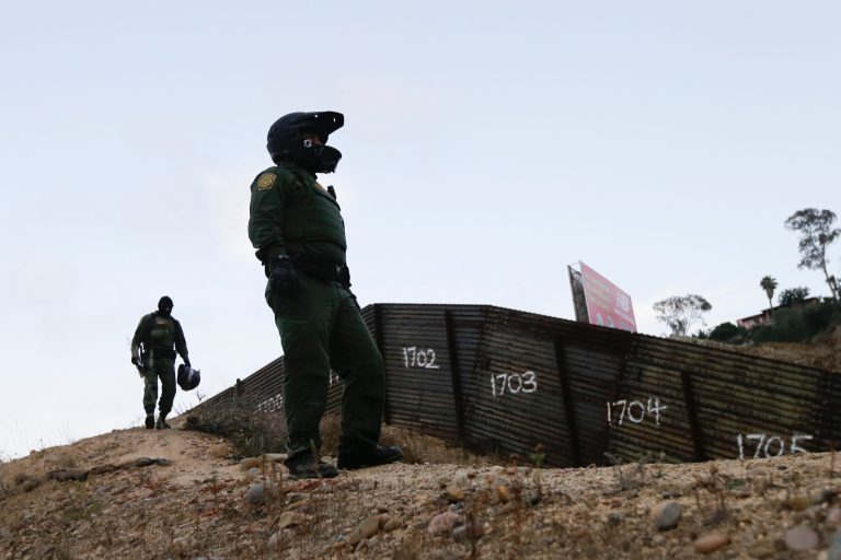 In this June 22, 2016 photo, Border Patrol agents stands near a border structure in San Diego. (AP Photo/Gregory Bull)