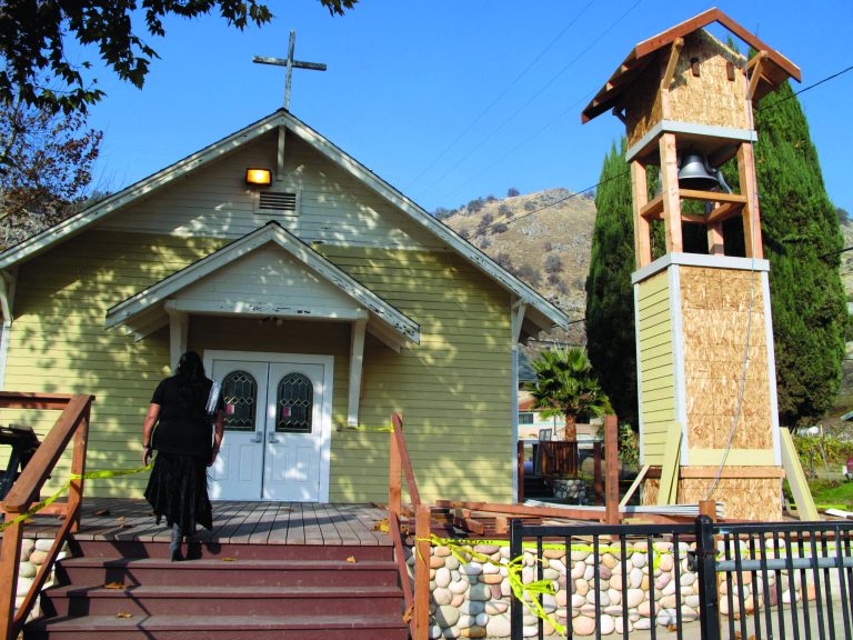 Rhoda Hunter, tribal council secretary of the Tule River Indian Reservation, walks into Mater Dolorosa Catholic Church for Mass, Sunday, Dec. 9, 2012, at the Tule River Indian Reservation in California. The church bell, its tower being renovated, has tolled throughout the day on Sunday to honor those killed in what many believe is the worst mass murder in tribal history. Hector Celaya, 31, is a suspect in shootings in which three people died and four others, including two young girls, were wounded Saturday, Dec. 8, 2012, on the reservation in the Sierra foothills of California's Central Valley. Since 1933 the church bell has slowly tolled to alert tribal members when someone dies. 