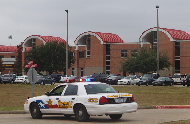   A police vehicle is parked near the entrance of North Shore High School after a shooting occurred Wednesday, Dec. 5, 2012, in Houston. Police say a high school student taken into custody after he sent a text message to a friend saying he wanted to hurt himself shot himself with a hidden gun while handcuffed inside a patrol car. Authorities on Thursday said deputies did not conduct a complete search of the student, and failed to find the hidden gun. (AP Photo/Houston Chronicle, Cody Duty) MANDATORY CREDIT  