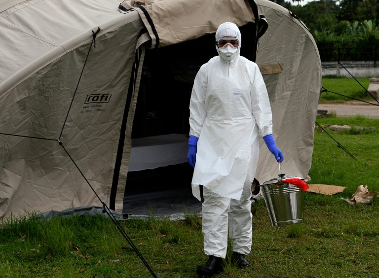 In this Sept. 24, 2014 photo, nurse Dalila Martinez, trainer of the Cuban medical team to travel to Sierra Leone, practices proper disposal at a training camp, in Havana, Cuba. Cuba's health ministry is sending more than 160 health workers to help stop the raging Ebola outbreak in Sierra Leone in early October. They will stay for six months. (AP Photo/Ladyrene Perez, Cubadebate)