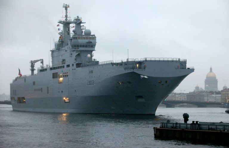 A man watches from a jetty as a Mistral-class French amphibious warship docks on the Neva River in downtown St. Petersburg, Russia, Monday, Nov. 23, 2009. (AP Photo/Dmitry Lovetsky)