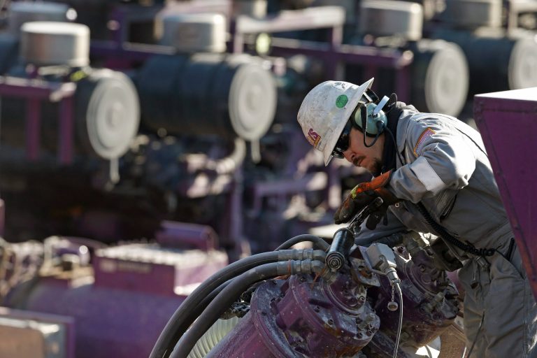 A worker oils a pump during a hydraulic fracturing operation at an Encana Corp. well pad near Mead, Colo., on March 25, 2014. (AP Photo/Brennan Linsley)