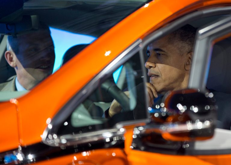 President Barack Obama sits in a new Chevrolet Bolt electric car with Patrick Foley, controls manager for the Bolt EV at GM in Detroit, as he visits the 2016 North American International Auto Show in Detroit, Wednesday, Jan. 20, 2016, to highlight the progress made by the American auto industry. (AP Photo/Carolyn Kaster)