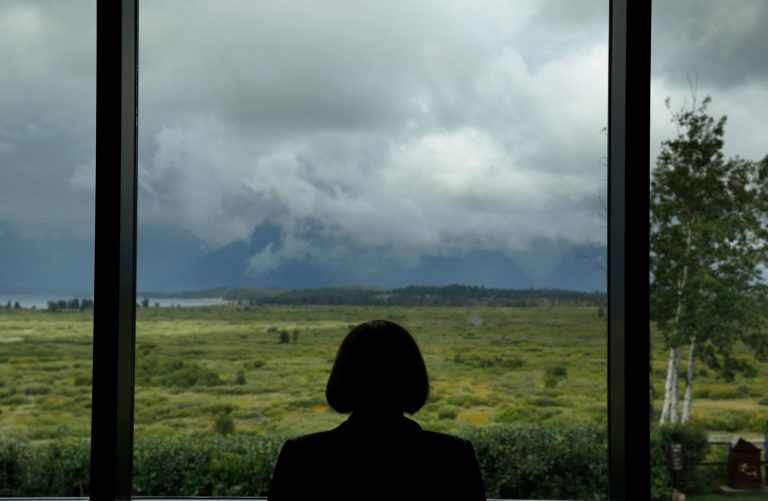 An economist looks out at the Teton Range during a break at the Jackson Hole Economic Policy Symposium at the Jackson Lake Lodge in Grand Teton National Park near Jackson, Wyo., Saturday, Aug. 23, 2014. (AP Photo)Â 