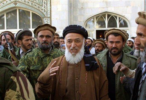 This Friday, Nov. 23, 2001 file photo shows former Afghan President Burhanuddin Rabbani as he emerges from the Pul-e-Khishti mosque after Friday prayers, surrounded by United Front bodyguards and supporters, in the capital Kabul, Afghanistan.