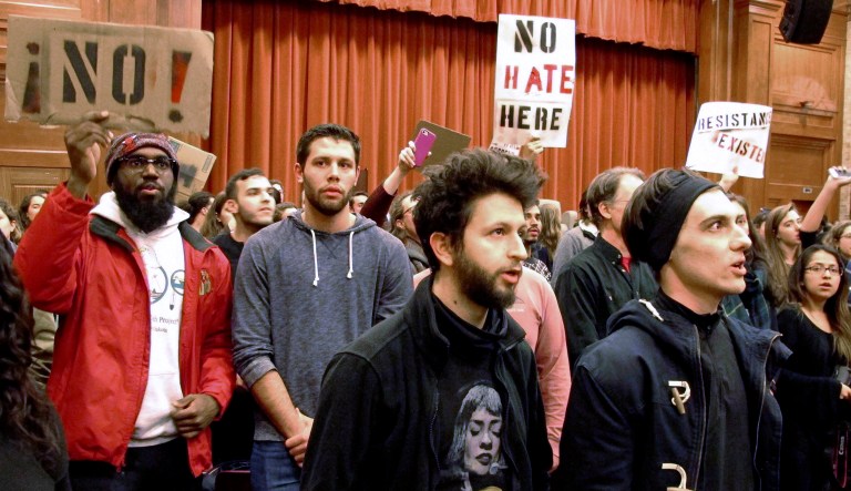 FILE - In this March 2, 2017, file photo, Middlebury College students turn their backs to Charles Murray, unseen, during his lecture in Middlebury, Vt. Hundreds of students protested his lecture, forcing the college to move his talk to an undisclosed campus location from which it was live-streamed to the original venue. Since the beginning of 2016, more than two dozen campus speeches have been derailed amid controversy, according to the Foundation For Individual Rights In Education, a group that monitors free speech on campuses. (AP Photo/Lisa Rathke, File)