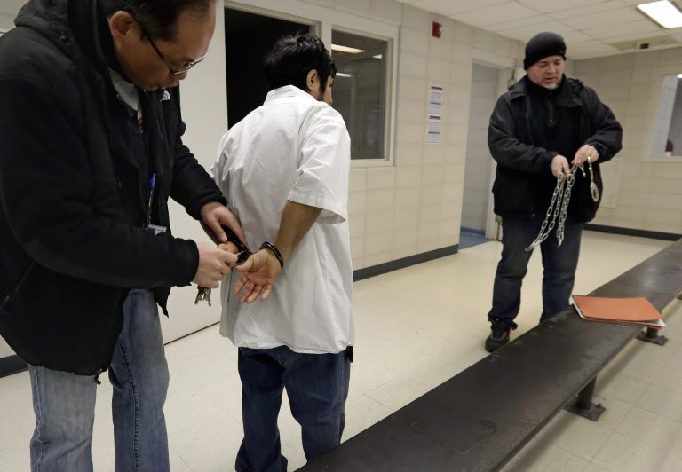 In this March 3, 2015 photo, Immigration and Customs Enforcement officers process an arrestee at their New York headquarters, after a series of early-morning raids. Immigrant and Customs Enforcement say an increasing number of cities and counties across the United States are limiting cooperation with the agency and putting its officers in dangerous situations as they track down foreign-born criminals. Instead, more of its force is out on the streets, eating up resources and conducting investigations because cities like New York and states like California have passed legislation that limits many of the detention requests issued by immigration authorities. (AP Photo/Richard Drew)