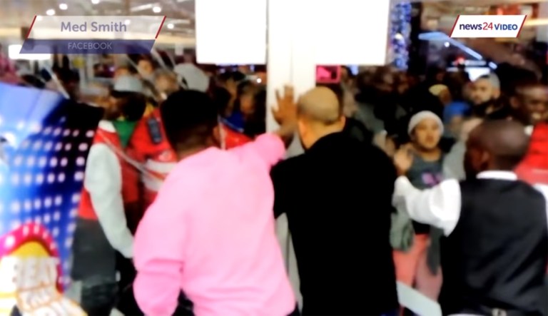 Staff at a department store in Cape Town appeared to unlock the doors before an impatient mass of people streamed in, breaking the glass. (Image courtesy screenshot)