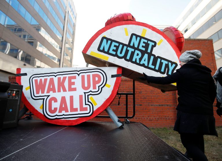 Sammi LeMaster helps to dismantle a large alarm clock display that reads 