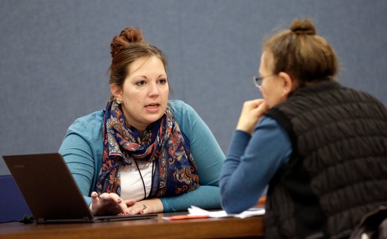 Amanda Deardorff, left, a health enrollment navigator with Open Door Health Solutions, helps Valerie Kazer through the process of signing up for coverage under the Affordable Care Act in Muncie, Ind., on Dec. 26. (AP Photo/AJ Mast)
