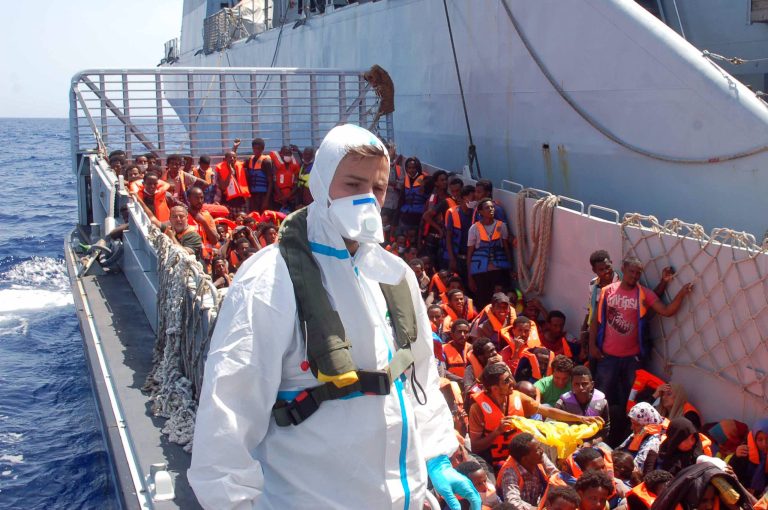 In this Picture released by the Italian Navy, Monday, Aug. 25, 2014, migrants wait to be boarded on the San Giusto Navy ship, along the Mediterranean sea, off the Sicilian island of Lampedusa, Saturday, Aug. 23, 2014. Italian Interior Minister Angelino Alfano renewed his demand for the European Union to relieve pressure on Italy, which has seen some 100,000 migrants arrive so far this year alone. The country says it spends 9.5 million euros ($13 million) a month to operate the beefed-up air and sea patrols that were launched after more than 360 migrants drowned off the Italian island of Lampedusa last October. 