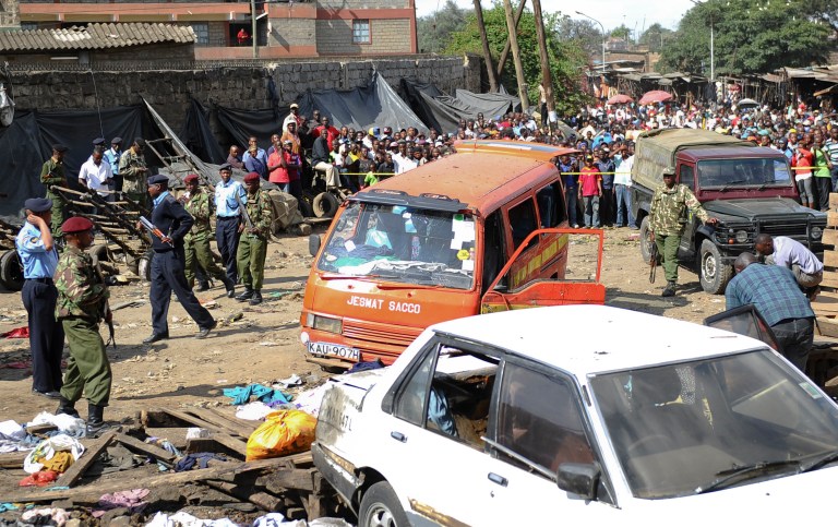 EDS NOTE: RECROP OF NAI113. Security forces secure the scene at the site where two blasts detonated, one in a mini-van used for public transportation, in a market area of Nairobi, Kenya Friday, May 16, 2014. Two blasts hit Kenya's capital on Friday, killing a number of people and injuring many more, in what appeared to be the latest in a string of increasingly frequent terror attacks. (AP Photo)