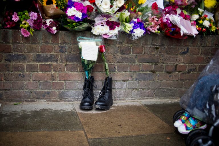 FILE - In this Friday, May 24, 2013 file photo, military boots are laid in tribute outside the Woolwich Barracks, in London, in response to the bloody attack on Wednesday when a British soldier was killed in the nearby street. Counterterrorism police on Saturday were questioning a friend of Michael Adebolajo, one of two suspects in the savage killing of British soldier Lee Rigby. The friend, Abu Nusaybah, was arrested immediately after he gave a television interview telling his story about how Adebolajo may have become radicalized. (AP Photo/Bogdan Maran, File)